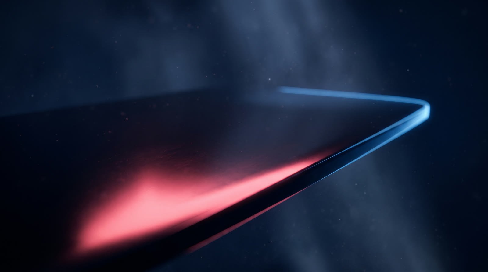 A polished dark surface lit by a sweep of coral light